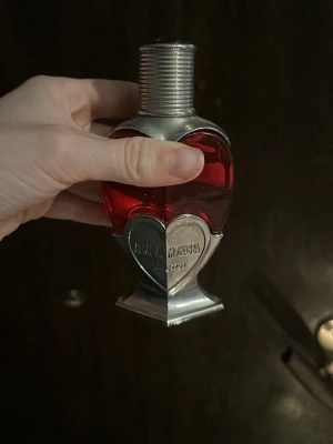 Unik hjärtformad parfymflaska - Snygg parfym med hjärtformad flaska och metalliska detaljer. Perfekt för dig som vill sticka ut och ge din samling en cool touch. Märket  syns tydligt på flaskan. denna är svår att få tag och HÅLLER länge!! Den har varit min signatur doft men nu är de dags för mig med nytt, därför använd 1/4 del…