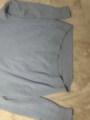 Ljusblå stickad tröja från Polo Ralph Lauren - Säljer en ljusblå stickad tröja från Polo Ralph Lauren med klassisk logga broderad på bröstet. Tröjan har rund hals, ribbade muddar och nederkant samt långärmad passform. Perfekt för dig som gillar stilrena och tidlösa plagg. *Nypris 2300kr*