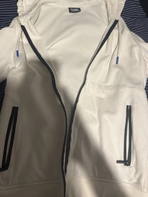 Karl Lagerfeld zip hoodie - Vit fin zip hoodie från Karl Lagerfeld. Den passar inte mig längre och har använts minimalt antal gånger och är därför i bra skick! Skulle säga att den passar både S och M rätt bra, skriv för mer info