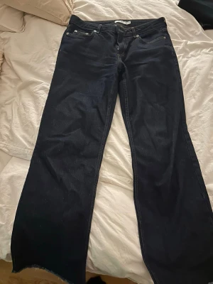 Mörkblå wide jeans från NA-KD - Säljer ett par mörkblå jeans från NA-KD i storlek 38. Modellen har breda ben och låg midja. Avklippta ner till, passar mig som är 165 cm och då går de över skorna.