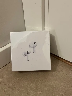 AirPods Pro (2nd generation) MagSafe USB-C - Helt nya AirPods Pro (2nd generation) med MagSafe-laddningsetui (USB-C). Oöppnad förpackning, senaste modellen med aktiv brusreducering, transparensläge och förbättrad batteritid. Perfekt för musik, samtal och träning. Inga synliga defekter eller slitage.
