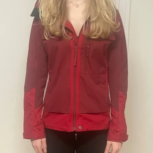 Röd vindjacka från Lundhags - Hej, jag säljer denna vindjacka från Lundhags då den inte kommer till användning. Den är i mycket bra skick då jag har andra liknande som jag använt flitigare. Inköpspris 3400 kr 
