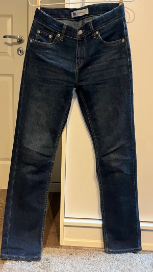 Levi's 511 Slim mörkblå jeans - Snygga Levi's 511 Slim jeans i mörkblå tvätt med klassiska fem fickor och kontrastsömmar. Modellen har en slim passform och raka ben, perfekt för dig som gillar en modern och stilren look. Ikonisk Levi's-lapp bak i midjan och röd etikett på bakfickan.