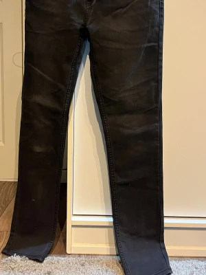 Levi's 512 Slim Taper svarta jeans - Svarta Levi's 512 Slim Taper jeans med klassisk femficksdesign och snyggt taperat snitt. Jeansen har bälteshällor, knapp och dragkedja fram samt Levi's patch och röd etikett bak. Materialet är jeans med en mjuk känsla och slim passform.