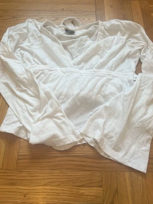 Vit topp med snörning - Fin vit topp med snörning bak. V- ringad.