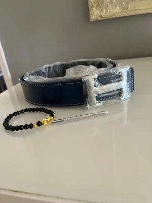 Mörkblått H bälte  - Säljer mitt herrmes bälte 115cm helt nytt. Armband ingår. Hör av er vid frågor och funderingar 