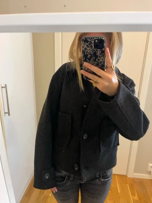 Svart ulljacka från lager 157 - Säljer en svart, croppad jacka från 157 med klassisk krage och stora fickor framtill. Jackan har knappar hela vägen och långärmade armar💖