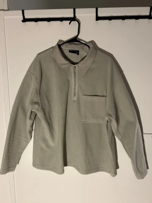 Beige fleecepiké från ASOS DESIGN XL - Säljer en beige fleecepiké från ASOS DESIGN i storlek XL. Tröjan har en klassisk krage i kontrasterande tyg, half zip framtill och en stor bröstficka. Perfekt för dig som gillar chill och stilren look.