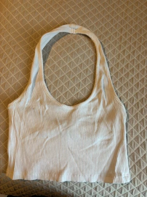 Ribbad croppad linnetopp i vitt och svart - Två croppade linnetoppar i ribbad bomull, en vit och en svart. Båda har rundad hals och ärmlös design med breda axelband. Perfekt för sommarens alla tillfällen och enkel att matcha med jeans eller shorts. Båda för 50kr