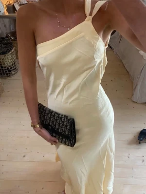 Ljusgul balklänning - Elegant långklänning i ljusgul satin med öppen rygg. Figurnära passform. Pertekt for speciella tillfällen .Jag är 176 cm läng och brukar ha xs/s. Den är köpt i en Boutique i Frankrike kan regleras i höft och misja mha banden i ryggen och passar därmed fler storlekar. Skriv till mig innan köp då jag inte är hemma nu. Klänningen kan reserveras och skickas så snabbt jag är hemma🩷 begränsat antal först till kvarn! Helt ny, inga defekter💗