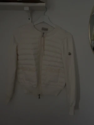 Vit cardigan från Moncler - Säljer en snygg moncler cardigan jacka i vit i storlek s, perfekt för dig som gillar att klä dig snyggt och gillar mode. Helt ny