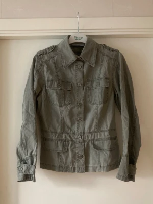 🍒Grön utilityjacka🍒 - 🍒UTILITY🍒Svinsnygg jacka med markerad midja, två bröstfickor med lock och slag på ärmarna och axlarna som detaljer. Kommer i ett 100% bomullstyg.🍒