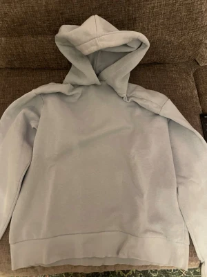 Blå Hoodie - Det är en ljusblå hoodie från ginatricot den är inte sliten och är i väldigt bra skick inga flexar heller 