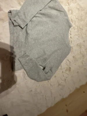 Grå sweatshirt från Pieces - En basic grå sweatshirt från Pieces i mjukt material. Tröjan har rund halsringning och långa ärmar, perfekt för chill dagar. Enkel och stilren design som passar till allt.