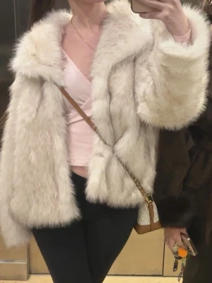 Fluffig vit pälsjacka - Säljer en superfluffig och lyxig vit pälsjacka med bred krage och lång ärm. Jackan har en oversized passform och känns riktigt mjuk och varm, perfekt för kalla dagar när du vill sticka ut lite extra.