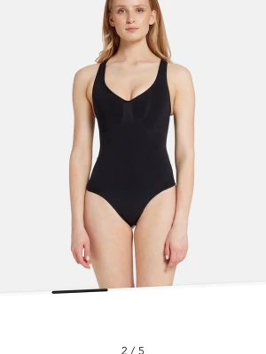 Skims bodysuit M - Skims bodysuit i storlek M. Säljer en svart, stilren body med djup urringning och breda axelband. Tillverkad i ett stretchigt och mjukt syntetmaterial som sitter tight mot kroppen. Perfekt att styla med jeans eller kjol för en clean look. 