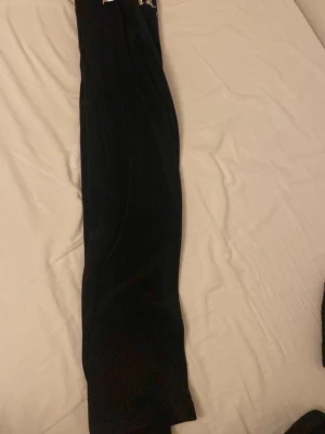 Svarta mjukisbyxor från juicy couture  - Svarta mjukisbyxor från juicy couture med dragsko i midjan och broderad logga på vänster sida. Byxorna har en rak passform och är gjorda i mjukt material som är skönt att ha på sig. 