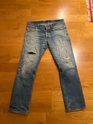 Nudie dry selvage - Tjena, säljer nu mina sjuka Selvadge jeans som jag har fått otroligt schyssta vits ord om. Jeansen är väldigt gamla enligt mannen i nudie butiken ”troligen tidigt 2000 tal”. Jeansen har fina fades men stora kontraster och schyssta slitningar som har varit på reparation i nudie butiken i Göteborg. Size w32 L34. Tveka inte på att höra av er vid mer frågor.