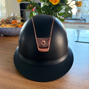 Samshield hjälm  - Snygg och modern ridhjälm från Samshield i matt svart med roséguld detaljer och glittrig panel framtill. Hjälmen är i storlek S/55 . Justerbar hakrem och bekväm passform.