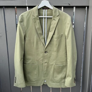 Grön kavaj från Morris, strl 48 - Snygg grön kavaj från Morris i bomull. Kavajen är i storlek 48. Perfekt till sommaren och fester. Tveka inte på att höra av dig vid frågor eller funderingar!