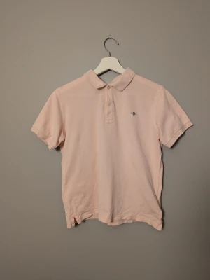 Rosa piké från Gant - Säljer en ljusrosa piké från Gant. Tröjan är lite liten för sin storlek men är i riktigt bra skick. Priset är inte hugget i sten och det är bara att höra av sig vid frågor och funderingar!