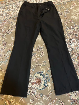 Svarta bootcut kostymbyxor BikBok - Säljer ett par svarta kostymbyxor från BikBok i storlek 38. Byxorna har bootcut passform.