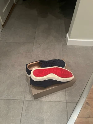 Louboutin skor - Tjena! Säljer ett par mörklblå loubs med vit sula. Skorna är använda men inga slitningar eller liknande. Skicket är 8/10 (har inte tvättat de så det är sänkt pris) hör av dig!!