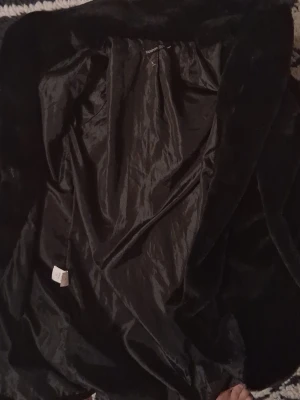 Svart pälsjacka från Boohoo - Säljer en svart pälsjacka från Boohoo i storlek 38. Jackan har en klassisk krage och är helsvart med mjuk pälsimitation på utsidan och slätt foder på insidan. Perfekt för dig som vill ha en snygg och varm look under kallare dagar. Helt oanvänd och tar endast plats så vill bli av med den. Perfekt för utgång.