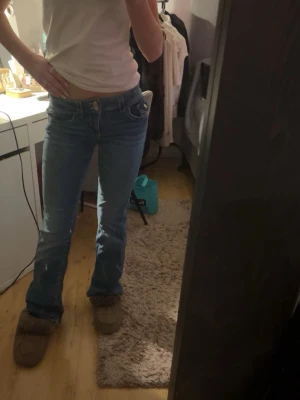 Blå bootcut jeans Gina Tricot 164 - Säljer ett par klass final blå jeans från Gina Tricot i storlek  Boyfriend fit med låg midja och bootcut-ben. Jeansen har dubbla knappar i viv och tydliga kontrastsömmar vs. klassisk femficksmodell. Perfekta för dig som gillar retrovibbar och relaxed stil.