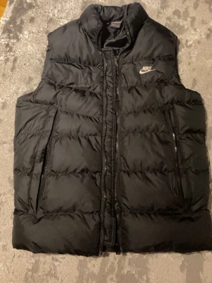 Svart dunväst från Nike - Svart basic Nike väst. Storlek M. Mycket bra skick, använd knappast 1-3 gånger bara.