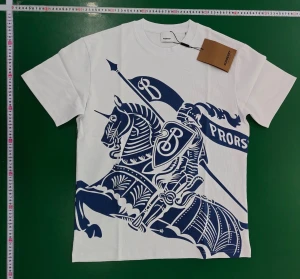 Vit t-shirt med blått tryck - Snygg vit t-shirt  med stort blått tryck av riddare och häst på framsidan. Klassisk rund hals och korta ärmar. Tillverkad i mjuk bomull för en skön känsla. Perfekt statement-plagg för dig som gillar exklusiva märken och cool design. Kan skicka 7-18 mer bilder privat 