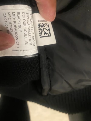 Svart quiltad pufferjacka Canada Goose - Säljer en svart pufferjacka från Canada Goose med quiltad framsida och stickade ärmar. Jackan har dragkedja och en snygg patch på ärmen med Canada Goose Arctic Program. Perfekt för dig som vill ha en stilren och varm jacka med cool design.