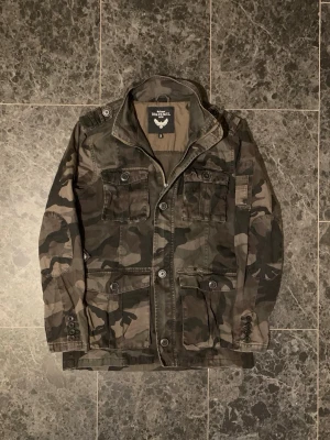 Camoflauge jacka  - Tja! Säljer en fet Field jacket i Camoflauge! I gott skick! Storlek S. Bara att höra av sig vid eventuella frågor!