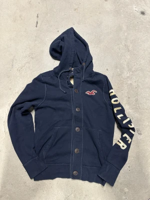 Vintage Hollister kofta med knappar - Extremt eftertraktad och sällsynt vintage  Hollister hoodie med knappar! Grymt skick, inga defekter - ser exakt ut som på bild! Storlek M. Skriv vid frågor!💬