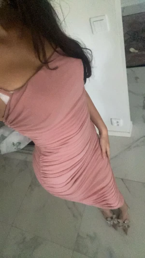 Rosa tight omlottklänning - Säljer en snygg rosa tight klänning med omlott-detalj och rynkade partier längs sidorna. Klänningen har axelband och har en kroppsnära passform som framhäver figuren. Perfekt för dig som vill sticka ut med en trendig look.