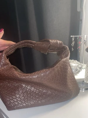 Brun axelväska med knut och mönster - Säljer en brun axelväska skriv för fler bilder.