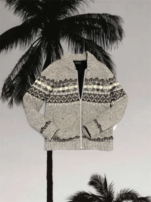 Cardigan - Kofta i grått med svart och vitt nordiskt mönster från Samsøe Samsøe. Den är stickad i ull, har lång ärm och dragkedja framtill. Perfekt för kalla dagar och har en chill, klassisk vibe. Ribbstickade muddar och hög krage ger extra mysfaktor.