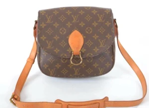 Louis Vuitton brun axelväska - Säljer en klassisk brun axelväska från Louis Vuitton med ikoniskt monogrammönster i beige. Väskan har justerbar rem i skinn och snygga guldfärgade metalldetaljer. Perfekt storlek för det viktigaste och en tidlös design som alltid är rätt. 