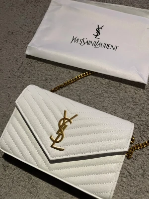Saint Laurent Envelope Chain Wallet - Klassisk vit läder väska från YSL, använd under något tillfälle men ser oanvänt ut, otroligt skick!🌟  Kvitto finns❗️  22,5 CM📏  Pris kan diskuteras  Postar inom 24h✅📦