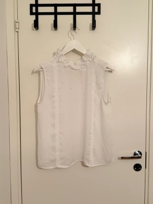 Blus  - Söt vit blus med några detaljer vid bröstet 