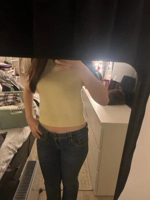 Ljusgul stickad topp från H&M Divided - Superfin ljusgul stickad topp från H&M Divided i storlek S. Modellen är croppad med korta ärmar och rund hals. Mjuk och fluffig känsla, perfekt för dig som gillar en enkel men söt look. Passar till jeans eller kjol för en chill vibe.