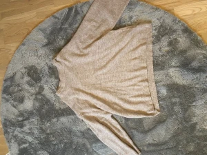 Beige stickad tröja från Lager 157 XL - Säljer en oversized beige stickad tröja från Lager 157 i storlek XL. Tröjan har rund hals, långa ärmar och ribbade muddar vid hals, ärmslut och nederkant. Perfekt för dig som gillar en loose och chill stil.