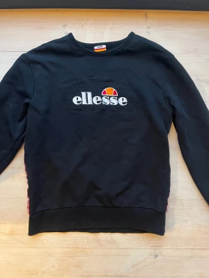 Svart sweatshirt från Ellesse L - Svart sweatshirt med revärer i sidorna från Ellesse. Ganska liten i storleken för att vara L. 