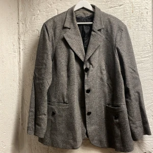 Oversized kavaj - Snygg grå kavaj med klassisk design och knappar framtill. Perfekt för en stilren men lite oversized look. Passar bra till både formella och semi-formella tillfällen. Ull, polyester, silke och elastan 