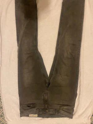 Slim fit grå jeans från Levis - Slim fit jeans från Levis i en mörkgrå ton. Klassisk femficksmodell med dragkedja och knappstängning. Snyggt smal passform som sitter tajt längs benen. Perfekt för dig som gillar en stilren och modern look bra o ha häng med dom 