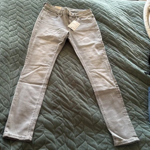 Grå skinny jeans från Esprit - Snygga ljusgrå skinny jeans från Esprit med klassisk femficksdesign och dragkedjegylf. Jeansen har en smal passform och är tillverkade i stretchig bomullsblandning för extra komfort. Perfekta för dig som gillar en stilren och enkel look.