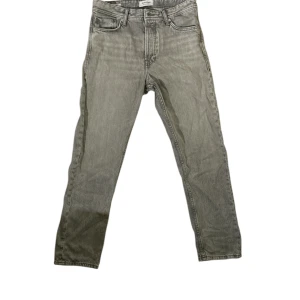 Grå jeans från Jack & Jones - Snygga grå jeans från Jack & Jones med klassisk femficksdesign och raka ben. Jeansen har en normal passform och perfekta för dig som gillar en stilren och enkel look.