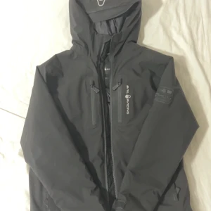 Svart Sail Racing dunjacka med huva - Använd fåtal gånger. nypris är 3000kr, mitt pris 1200kr. Skriv till mig om du har några frågor.