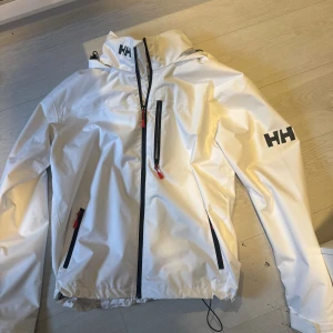 Helly Hansen jacka - Snygg vit helly Hansen. Använd max 2 gånger, ny skick. Storlek L med justerbart band nere vid höften.
