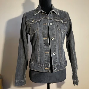 Mörkgrå jeansjacka från VM Jeans - Riktigt snygg jeansjacka från veromoda. Ärmlängd ca 60cm. Längd ca 55cm. Pris: 30kr 